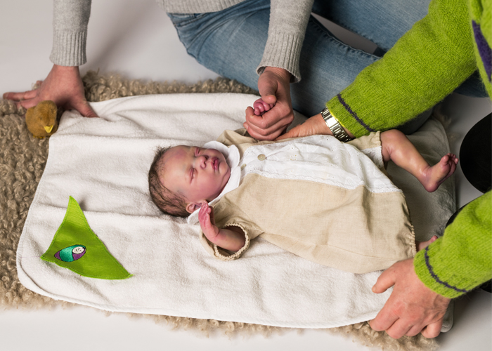 Fotografia Lorena mentre Lorena spiega a una mamma come posizionare sdraiato il neonato